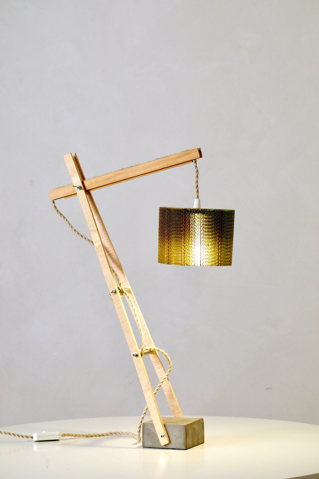 lámpara de sobremesa  un diseño artesanal hecho con materiales básicos; madera cemento y cartón ondulado