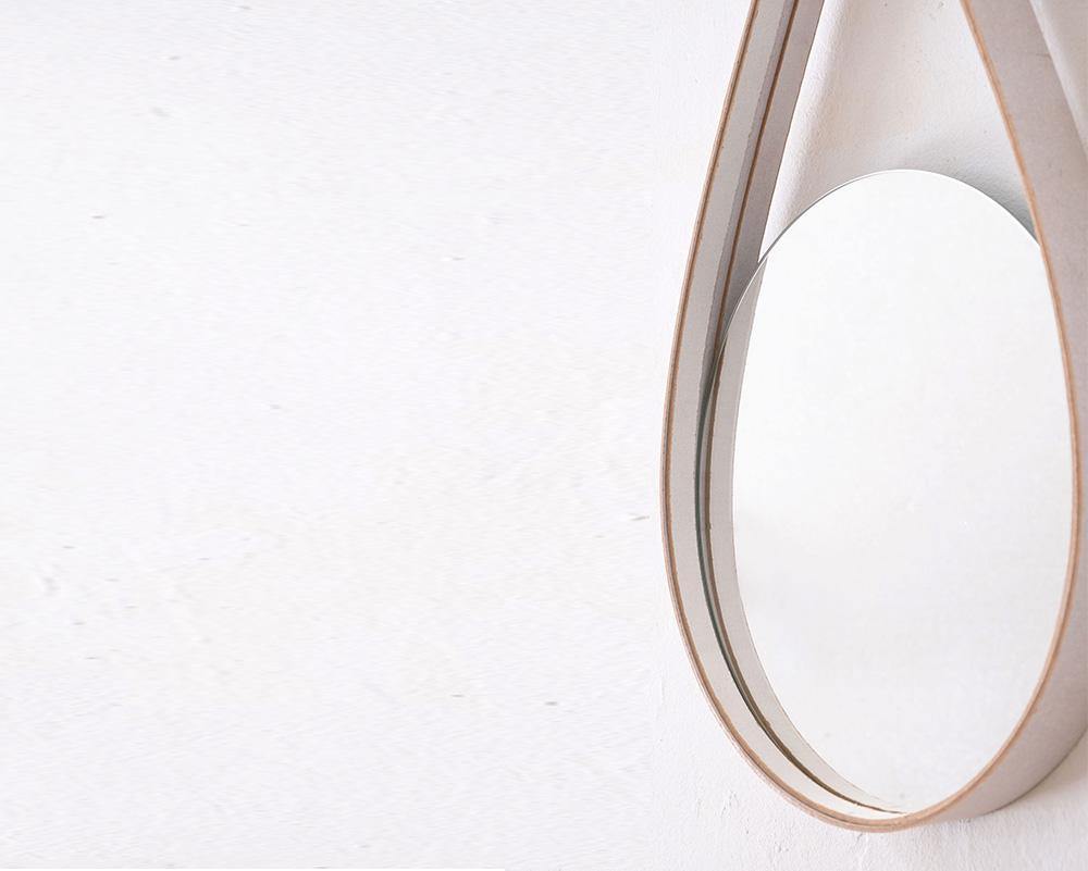 espejo  redondo sobre pared blanca, detalle