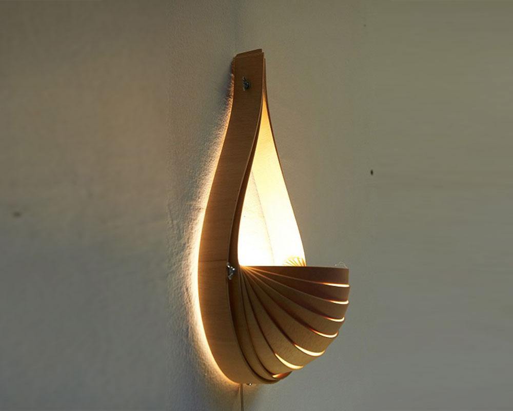 Aplique de madera , encendido irradia una luz desde su interior que atraviesa las lamas articulables .