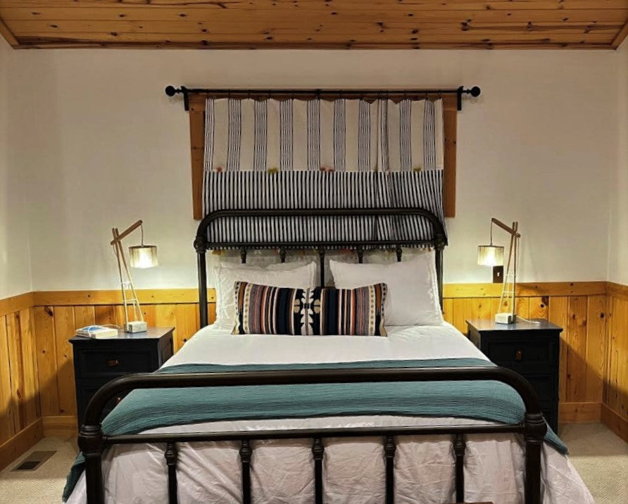 Dos lámpara sobre mesitas de noche dan la pincelada contemporánea al ambiente Boho de la habitación